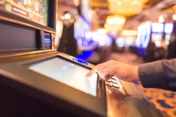 Arka planda canlı istatistiklerle dizüstü bilgisayarına odaklanan bir adam, EGE BET mobil uygulamasının spor ve oyun özelliklerini vurgular.